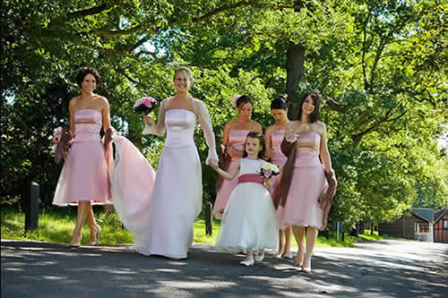 Bride, Bridesmaids and Flowergirl walking down the road